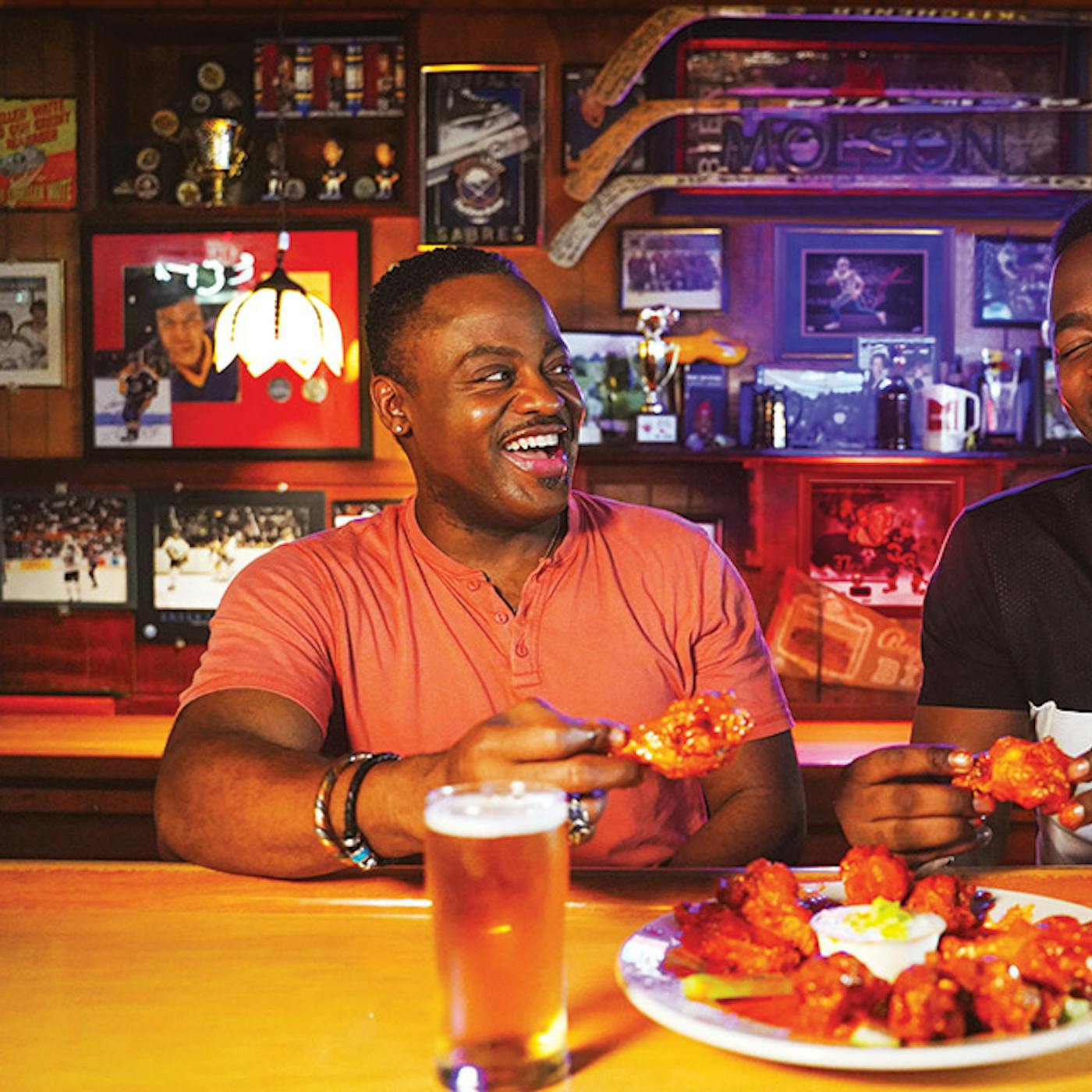 Two men eating wings at Nine-Eleven Tavern bar in Buffalo, New York (photo by Drew Brown))