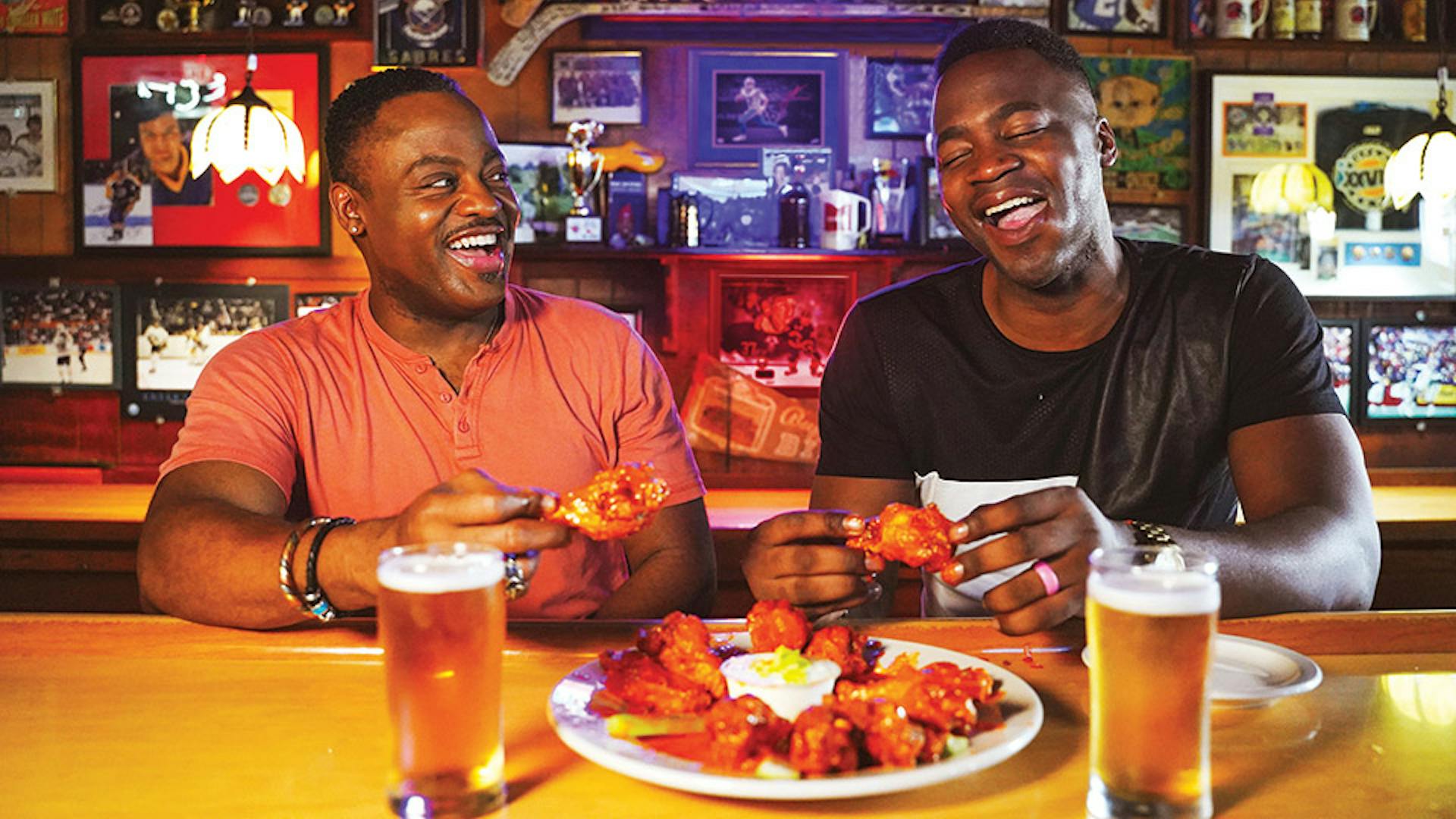 Two men eating wings at Nine-Eleven Tavern bar in Buffalo, New York (photo by Drew Brown)