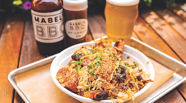 Barbecue dish with sauces and beer at Mabel's BBQ in Cleveland, Ohio (photo by Dustin Johnson)