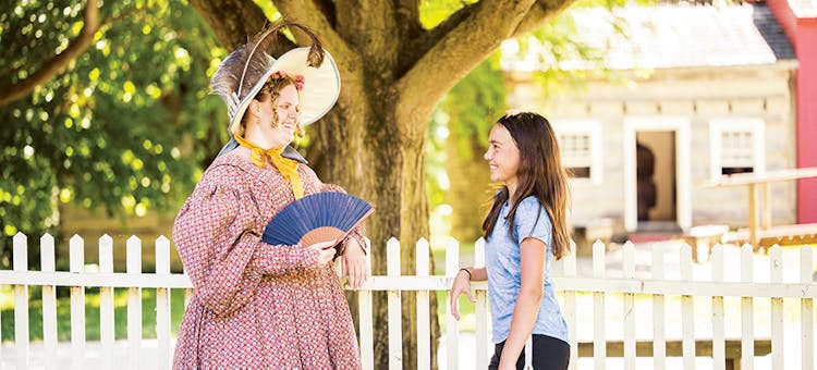 A costumed historical interpreter and visitor at Conner Prairie in Fishers, Indiana (photo by Aimed Photography LLC)