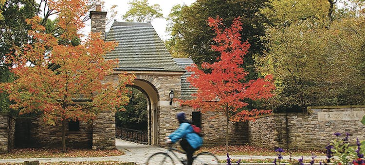 A bicyclist rides by the entrance to Frick Park in Pittsburgh, Pennsylvania (photo courtesy of Pittsburgh Parks Conservancy)