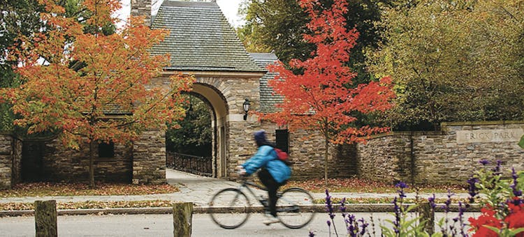 A bicyclist rides by the entrance to Frick Park in Pittsburgh, Pennsylvania (photo courtesy of Pittsburgh Parks Conservancy)