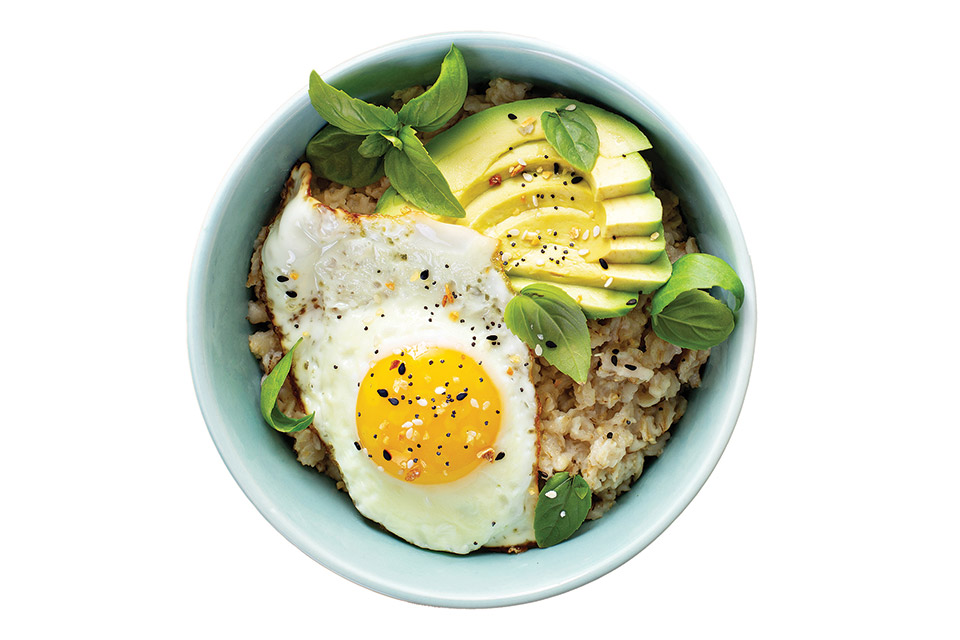 A morning breakfast bowl featuring egg, grains and avocado