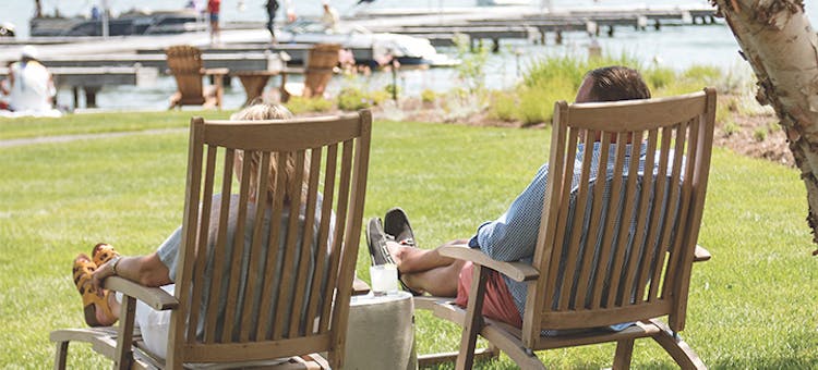 Couple sitting in lawn chairs lakeside at The Lake House on Canandaigua in Canandaigua, New York (photo courtesy of The Lake House on Canandaigua)
