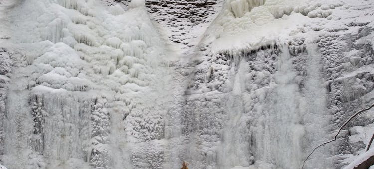 Jeri McMinn stands at the bottom of a huge ice formation.