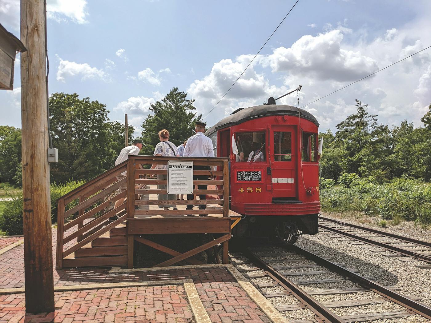 People standing on train platform next to red trolley car at Fox River Trolley Museum in South Elgin, Illinois (photo courtesy of Fox River Trolley Museum))