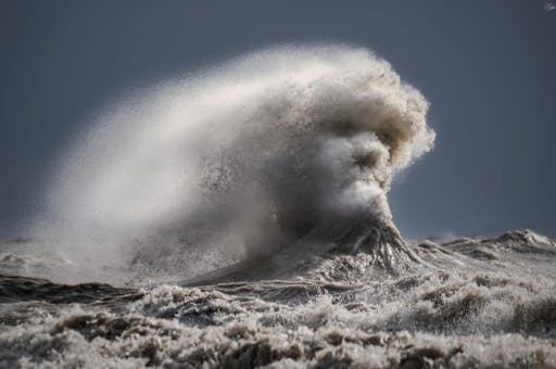 A crashing wave takes the form of a man's face.