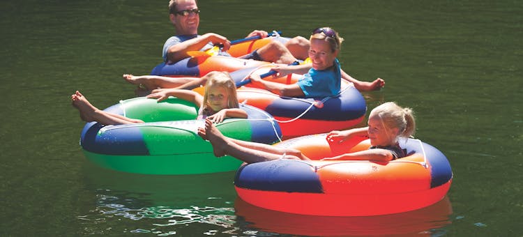Family floating in inner tubes on the Big Sable River in Ludington, Michigan (photo by Todd Reed)