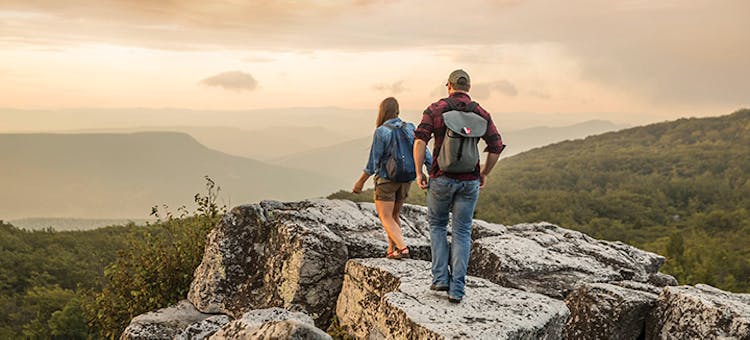 People hiking on rock overlooking mountains in Dolly Sods Wilderness in Davis, West Virginia (photo courtesy of West Virginia Department of Tourism)